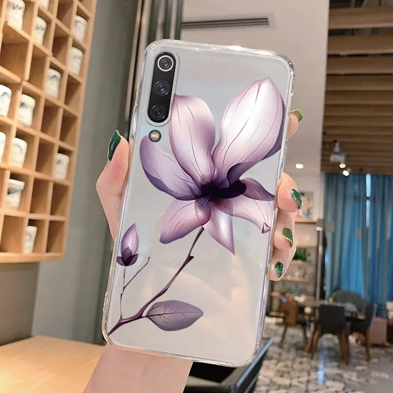 a woman holding a phone case with a purple flower on it
