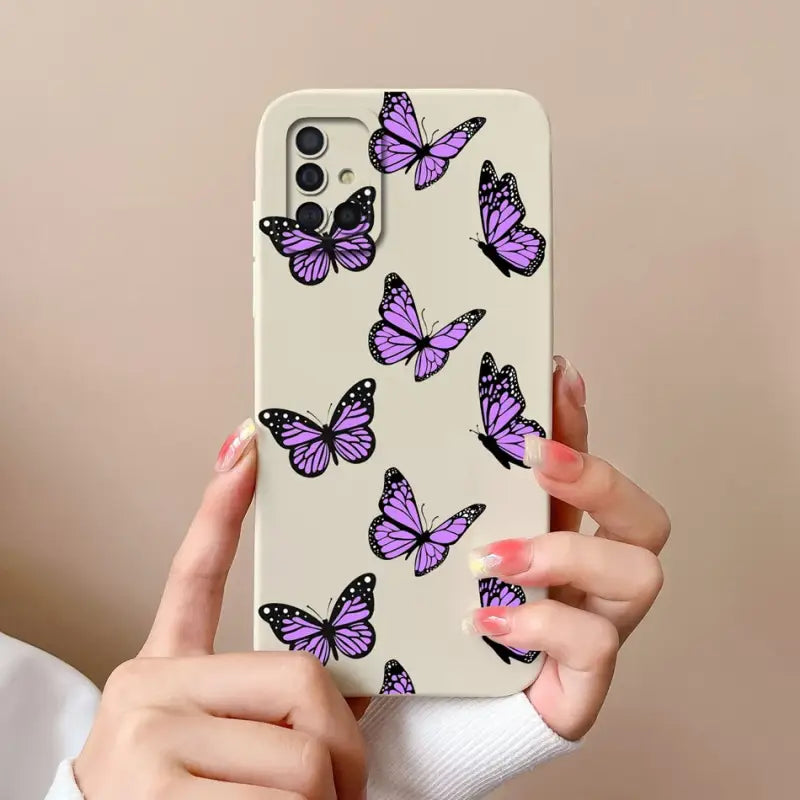 a woman holding a phone case with purple butterflies on it