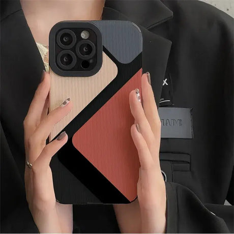 A woman holding a phone case with a red and black design