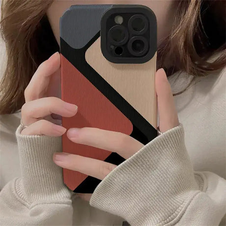 A woman holding a phone case with a red and black design