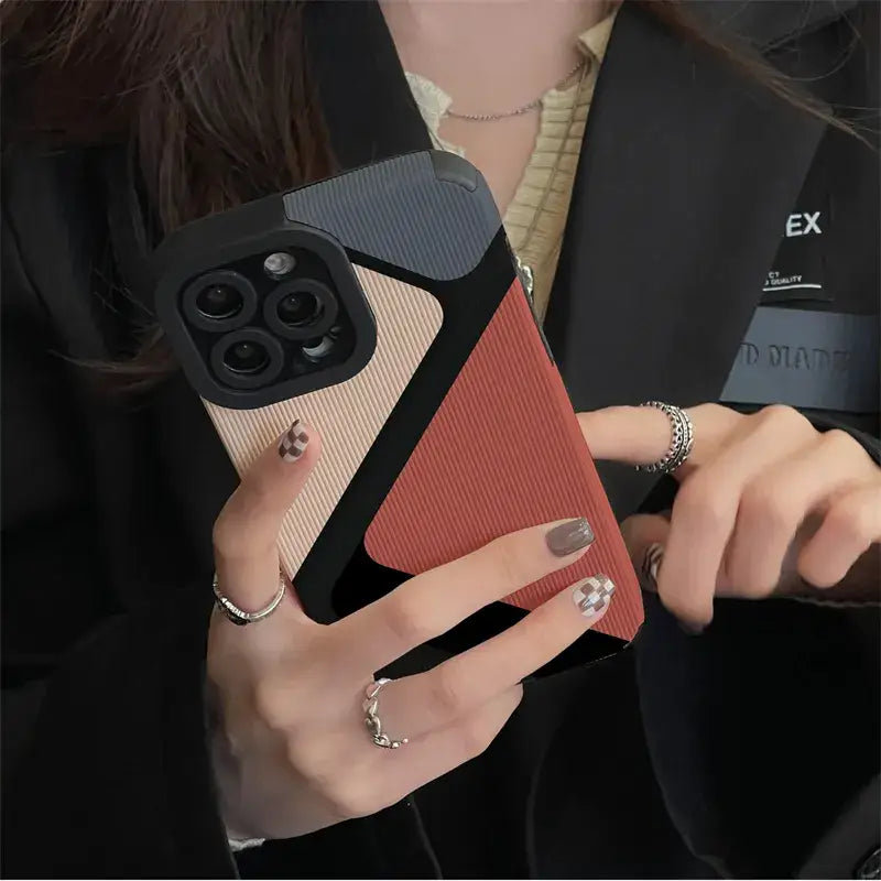 a woman holding a phone case with a red and black design