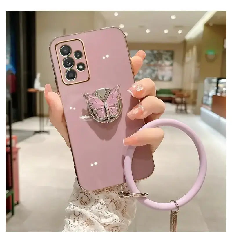 a woman holding a phone case with a ring