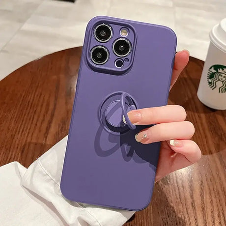 A woman holding a phone case with a ring on it