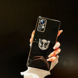 a woman holding up a phone case with a silver ring on it