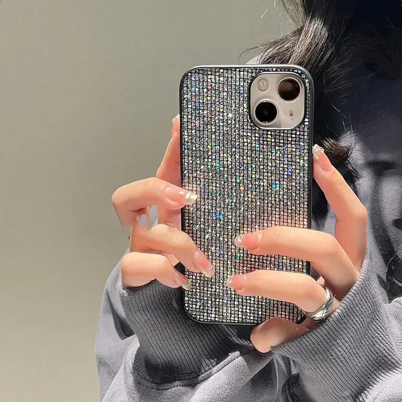 a woman holding a phone case with a silver glitter design