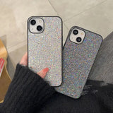 a woman holding a phone case with a silver glitter case