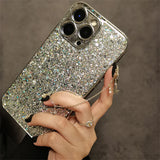 a woman holding a phone case with a silver glitter case