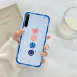 a woman holding a phone case with a smiley face on it