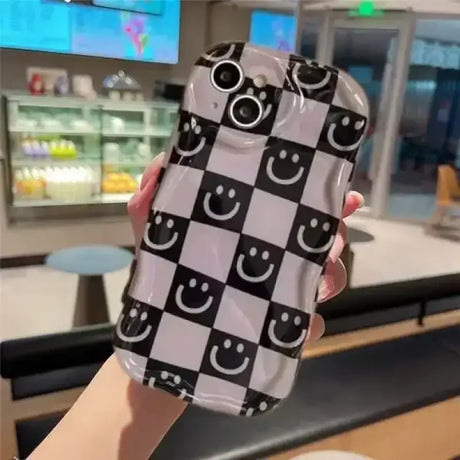 A woman holding a phone case with a smiley face on it