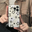 A woman holding a phone case with stars on it