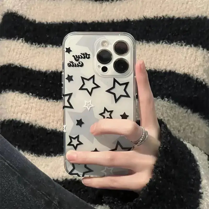 a woman holding a phone case with stars on it
