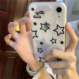 a woman holding up a phone case with stars on it