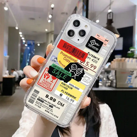 A woman holding up a phone case with stickers on it