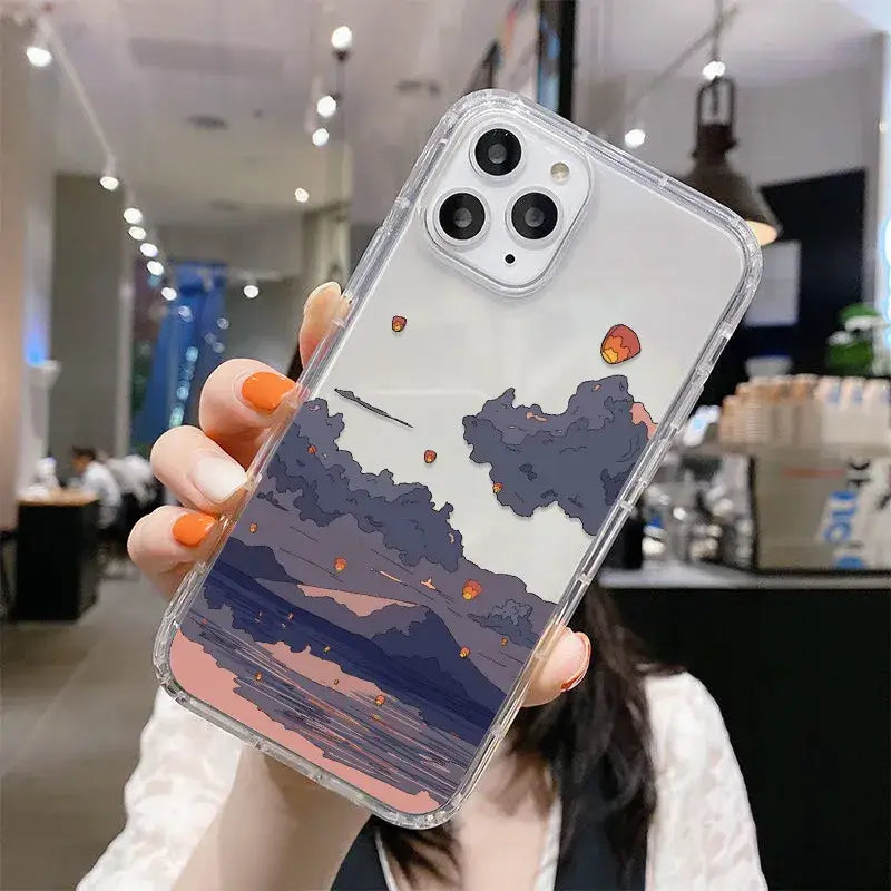 A woman holding up a phone case with a sunset scene