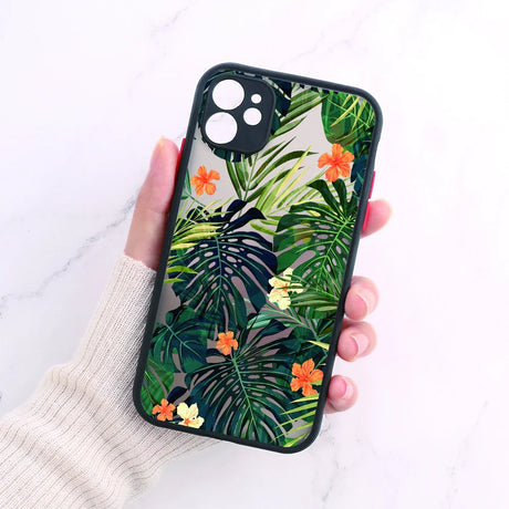 A woman holding a phone case with tropical leaves and flowers