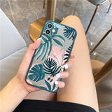 A woman holding a phone case with a tropical print