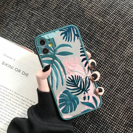 A woman holding a phone case with a tropical print