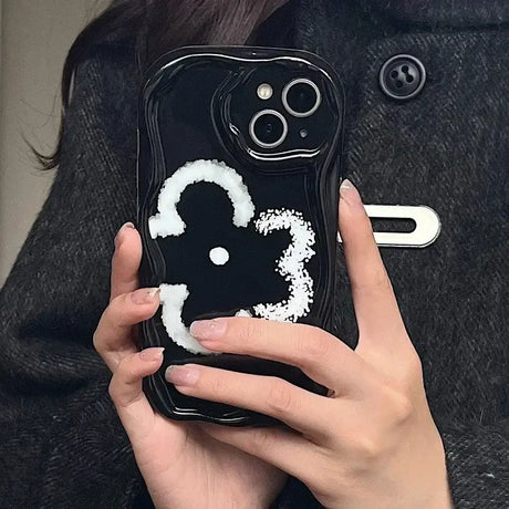 A woman holding a phone case with a white snow on it