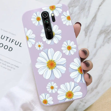 A woman holding a phone case with white flowers on it