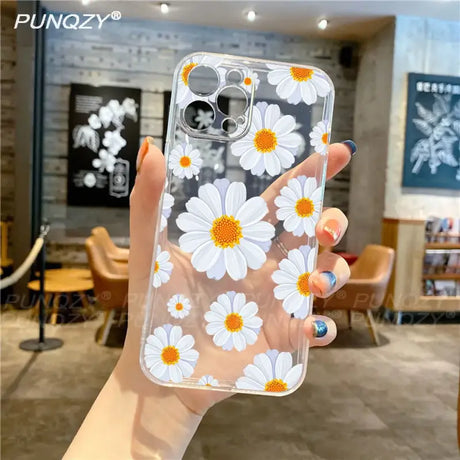 A woman holding a phone case with white flowers on it