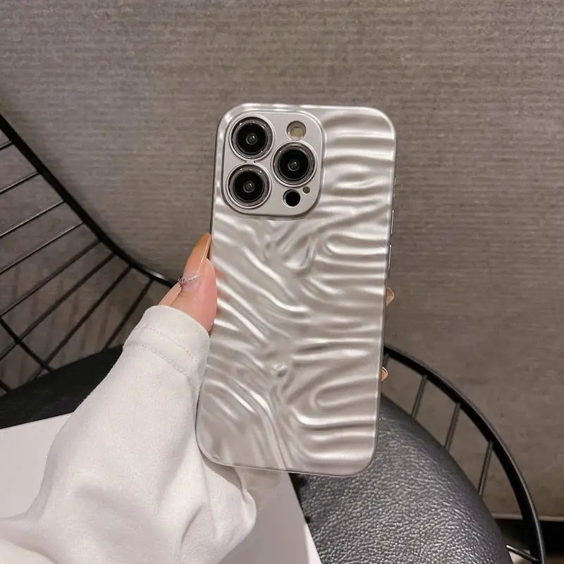 a woman holding a phone case with a white marble pattern