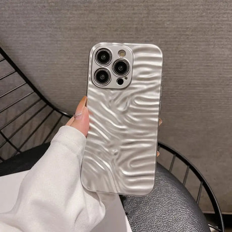 A woman holding a phone case with a white marble pattern