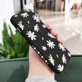 a woman holding a phone case with white flowers on it