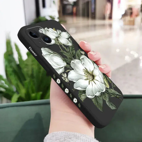 A woman holding a phone case with white flowers on it