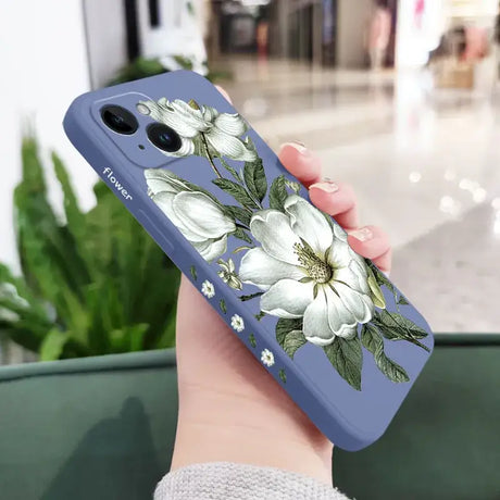 A woman holding a phone case with white flowers on it