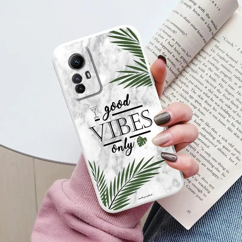 a woman holding a phone case with the words good vibes on it