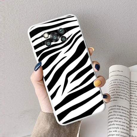 a woman holding a phone case with zebra print