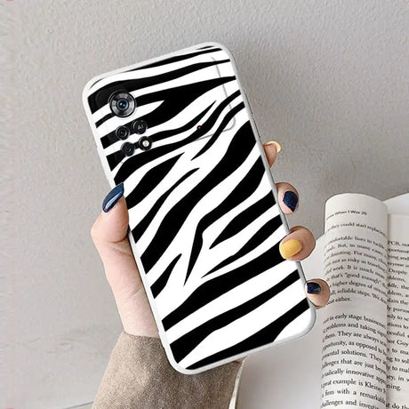 A woman holding a phone case with zebra print