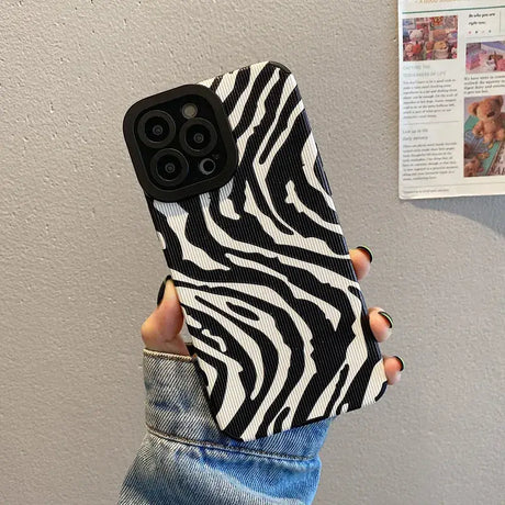 A woman holding a phone case with zebra print