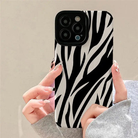 A woman holding a phone case with zebra print