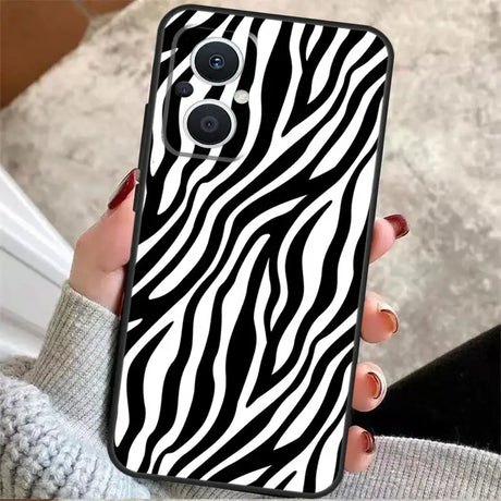 a woman holding a phone case with zebra print