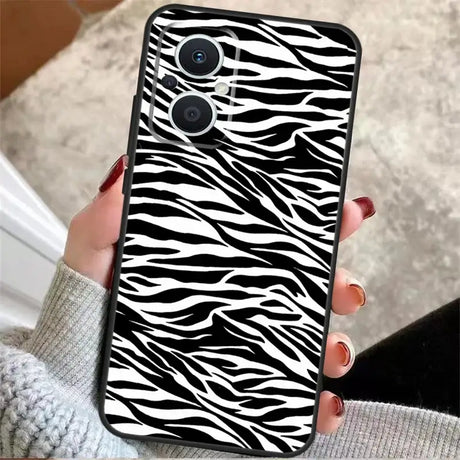 A woman holding a phone case with zebra print