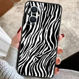 a woman holding a phone case with zebra print