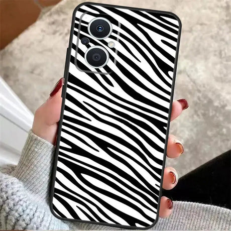 a woman holding a phone case with zebra print