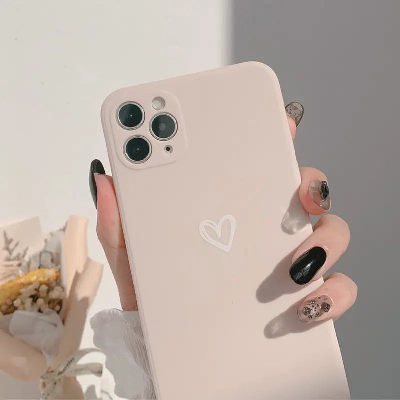 a woman holding a phone with a heart on it