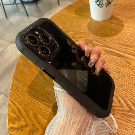 A woman holding a phone with a starbucks cup in the background