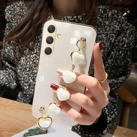 A woman holding a phone with a white heart shaped phone case