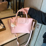 a woman holding a pink bag with a small white dog on it