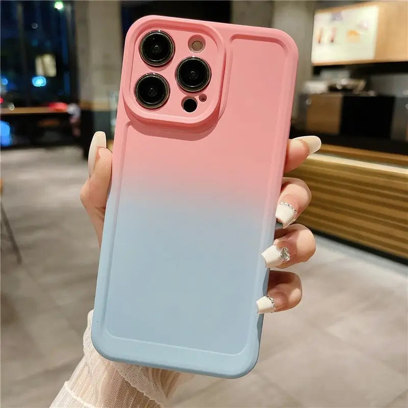 a woman holding a pink and blue iphone case