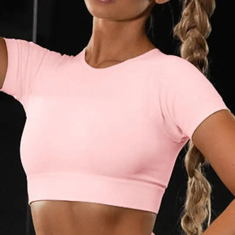 a woman in a pink crop top and black shorts