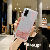 A woman holding up a pink glitter phone case