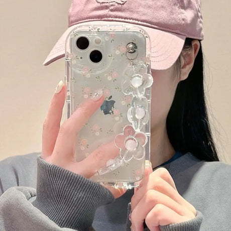 A woman wearing a pink hat and holding a phone case