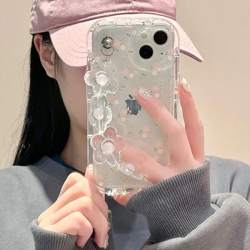 a woman wearing a pink hat and holding a phone case