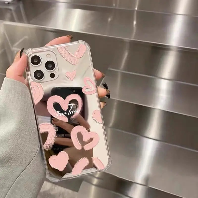 A woman holding a pink heart phone case