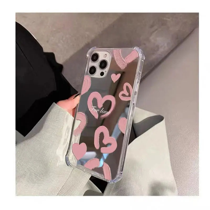 A woman holding a pink heart phone case