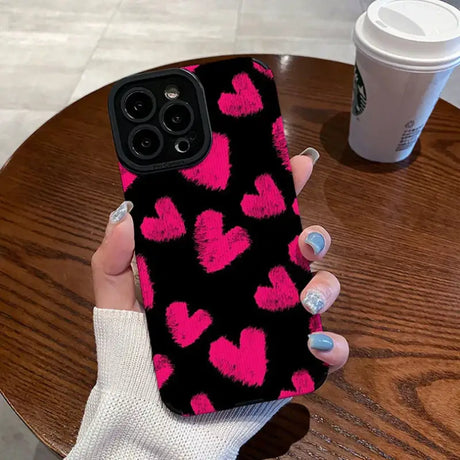 A woman holding a pink heart phone case